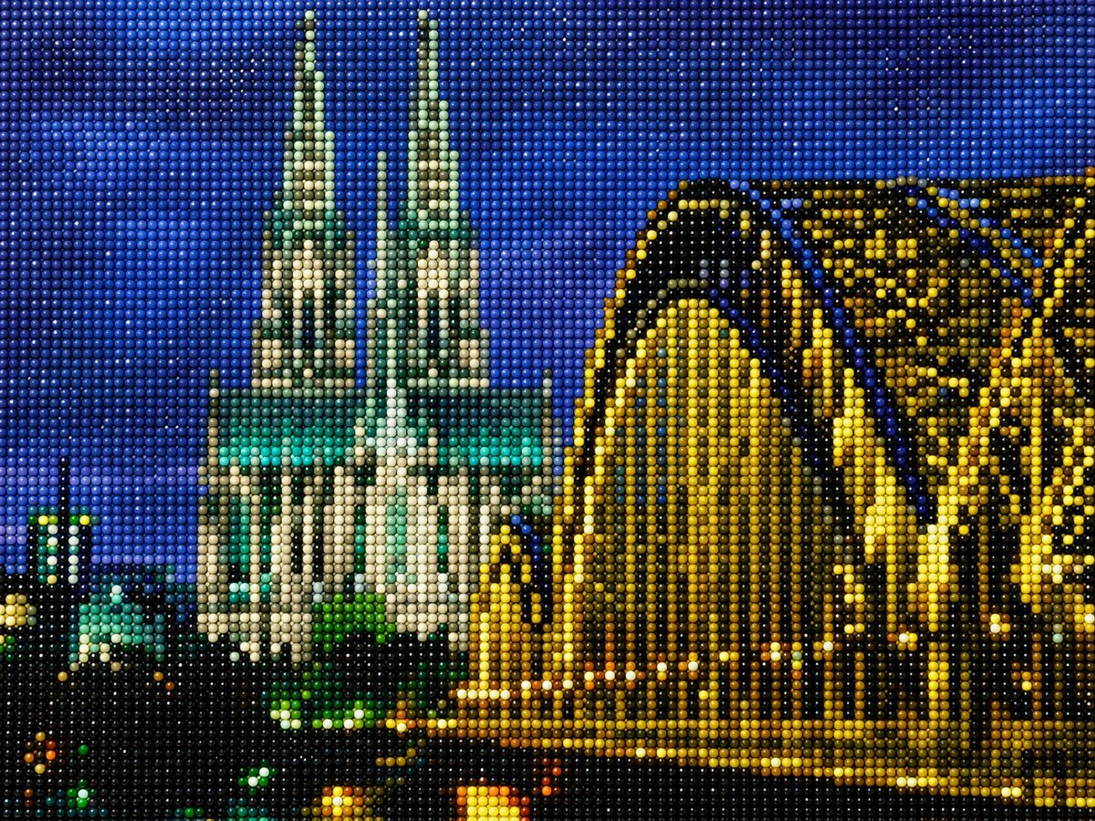 Finished Cologne Cathedral diamond painting kit artwork with the twin Gothic spires lit up at night above the golden bridge and river | Azurra Shop