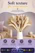 Promotional graphic showing a large dried pampas grass bouquet in warm neutral tones, arranged in a white ceramic vase on a wooden side table next to a cream sofa