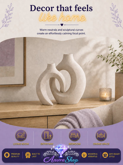 Entwined rice white ceramic vase duo displayed on a wood console beside a lit candle in a cozy living room