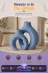 Blue entwined ceramic vase duo displayed in a hallway entryway with dried greenery