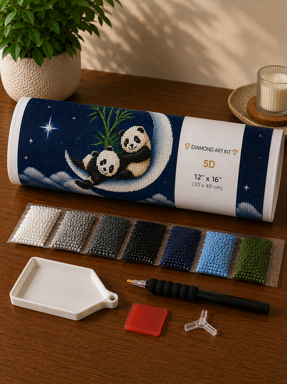 Baby pandas on a crescent moon diamond painting kit supplies – rolled canvas in tube, sorted diamond drill packets, applicator pen, wax pad and tray laid out on wooden surface — Azurra Shop
