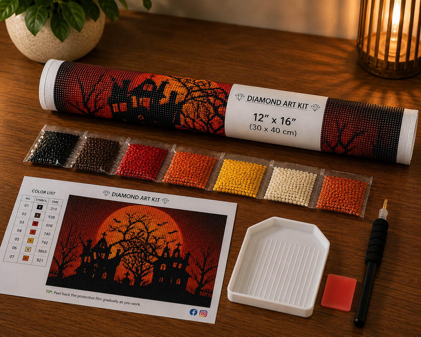 Blood Moon &amp; Haunted House Halloween Diamond Painting Kit – flat lay on warm wood surface showing blood moon haunted house canvas rolled in a Diamond Art Kit tube labeled 12"x16" (30x40cm), 7-color strip of resealable diamond drill bags in black, dark brown, red, orange, amber, yellow, cream, and rust tones, white grooved sorting tray, black applicator pen, red wax pad, and DMC color chart reference card with tip to peel back protective film gradually
