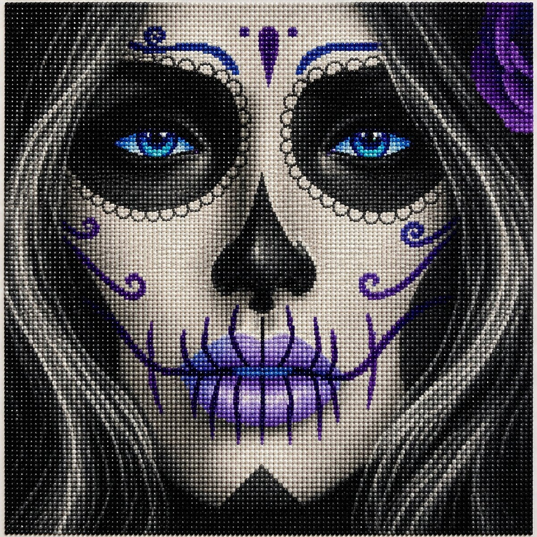 Close up of the finished blue eyed sugar skull diamond painting with striking blue eyes and purple face paint detail | Azurra Shop