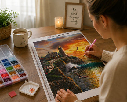 Working on the coastal lighthouse at golden hour kit at a warm wooden desk with drills, a candle, and a mug | Azurra Shop