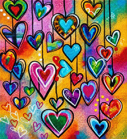 Close up of the finished colorful hanging hearts diamond painting on a rainbow background | Azurra Shop