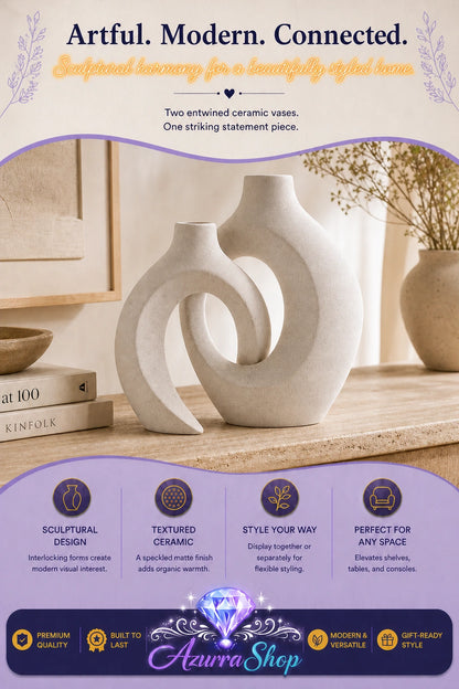Two rice white ceramic vases with interlocking open loop designs displayed together on a wooden console table