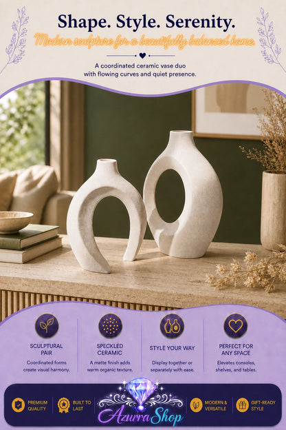 An asymmetric pair of rice white ceramic vases with open curved silhouettes styled on a console table