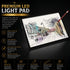 A3 LED light pad glowing under a city street sketch with a pencil resting on top