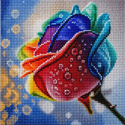 Finished rainbow rose diamond painting with a close up rose in blue purple orange and red petals with dew drops | Azurra Shop