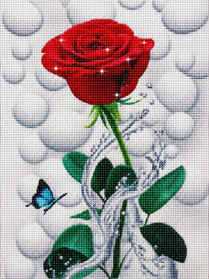 Close up of the finished red rose diamond painting with water droplets and a blue butterfly on a bubble background | Azurra Shop
