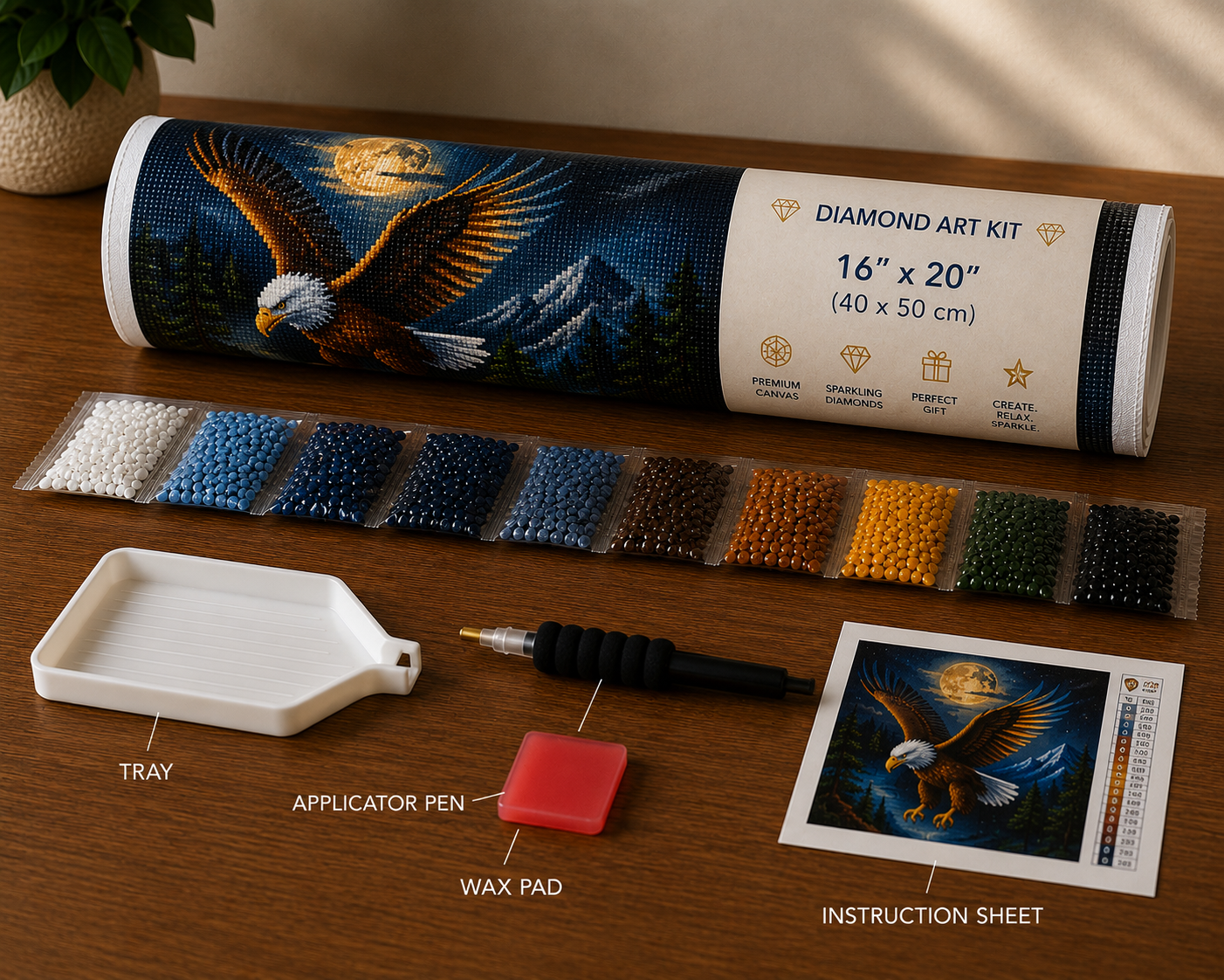 Bald eagle in flight diamond painting kit supplies – 16" x 20" canvas tube, sorted white, blue, navy, gold, brown and black diamond drill packets, applicator pen, wax pad, tray and DMC instruction sheet on wooden surface — Azurra Shop
