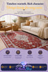 Red and beige tribal-pattern area rug in a living room with a cream sofa and armchair.